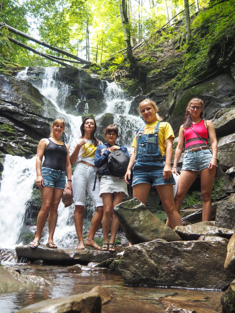 Girlish band near a beautiful waterfall