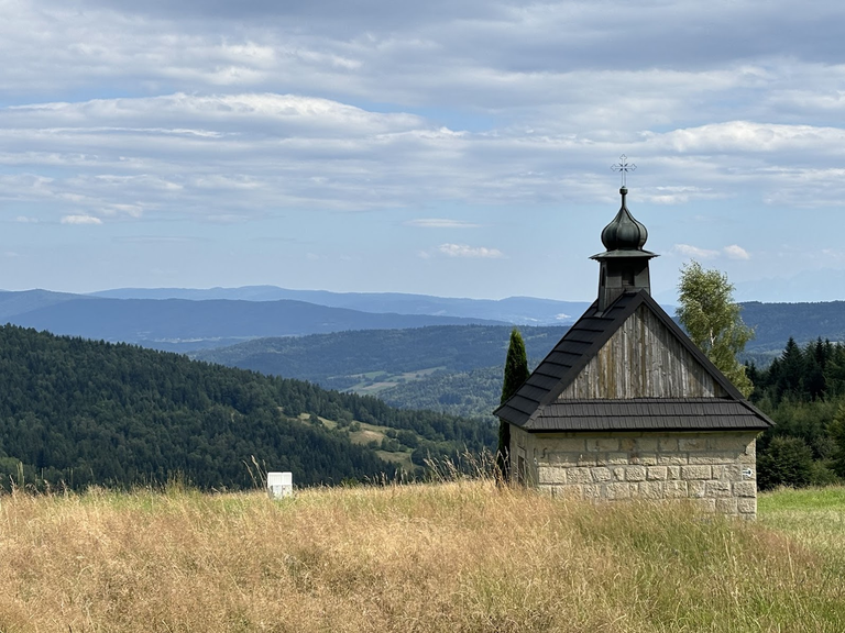 Kapliczka pod Koskową Górą. W dali Gorce, z najwyższym szczytem, Turbaczem.