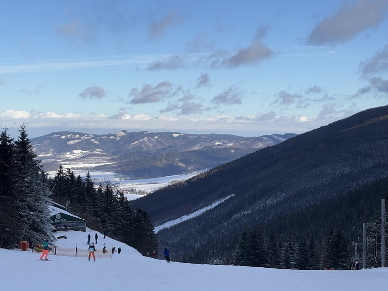 Stok narciarski na Wielkim Klinovcu. W dali czeska część Gór Opawskich (cz. Zlatohorská vrchovina). Najwyższy widoczny punkt to Bílé skály (923m n.p.m.)