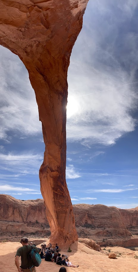 Resting under the towering Corona Arch, a perfect spot to marvel at nature’s grandeur.