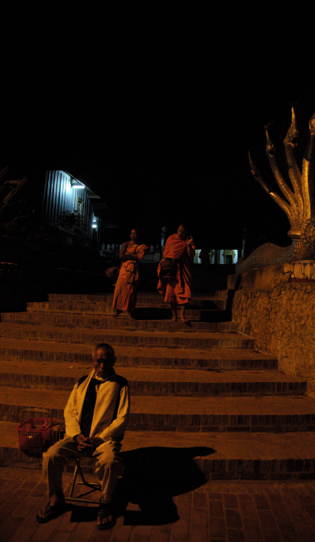 The elderly sit at his chair to wait the monk come  