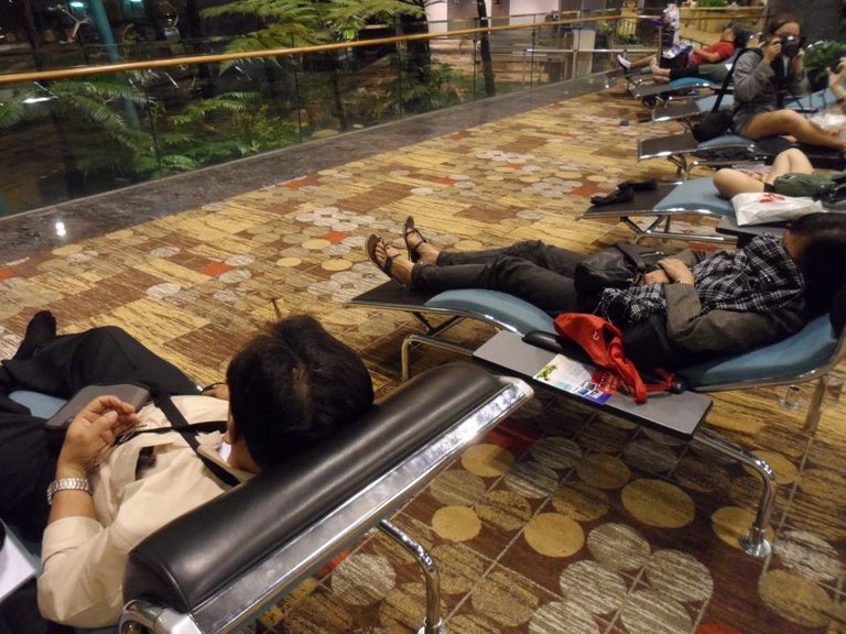 Both of my parents are having a nice rest while waiting for our scheduled flight.