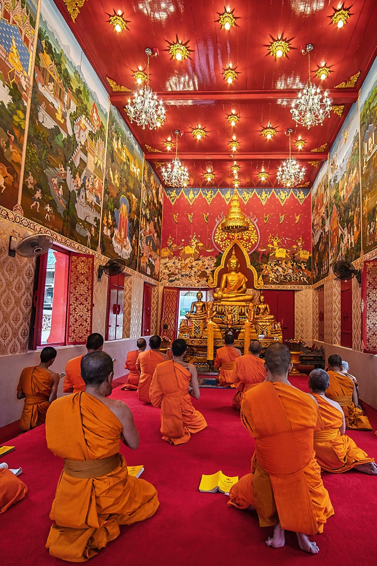 Monks chant religious texts in melodic rhythm.