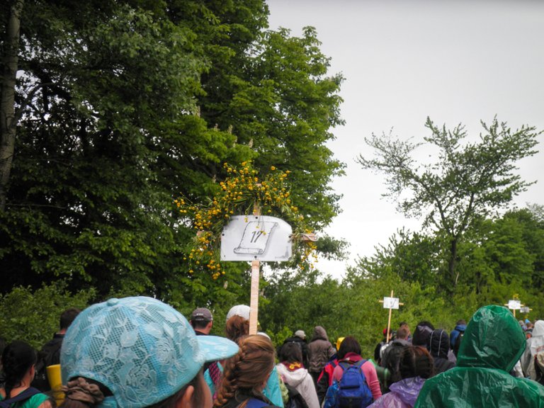 The pilgrims' column goes forward on the wet dirt road