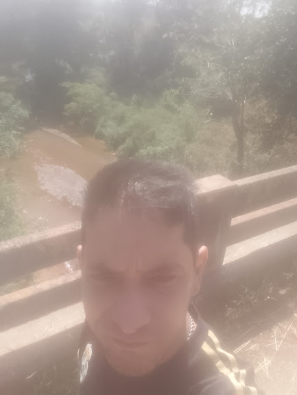 I took a photo on a bridge over a river, but the main camera of my mobile phone is damaged and takes a poor quality photo of a river with crystal clear water flowing over the bridge.
