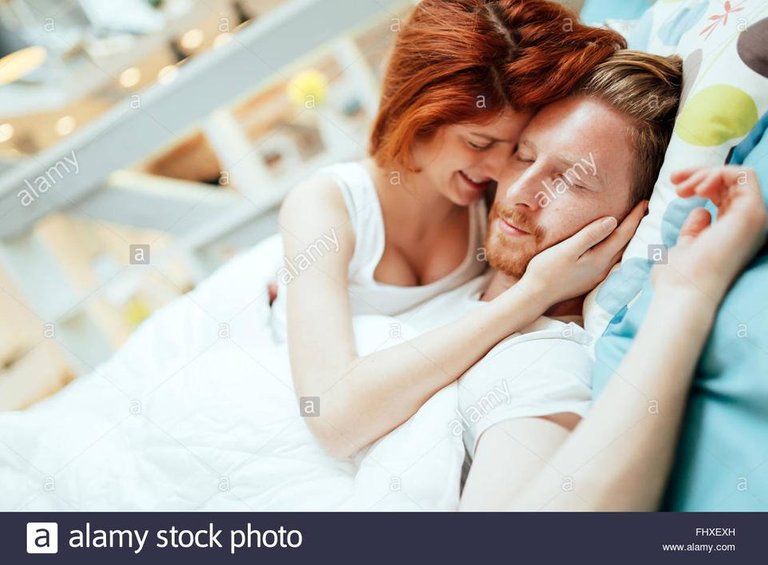 romantic-couple-in-love-lying-on-bed-and-being-passionate-FHXEXH.jpg
