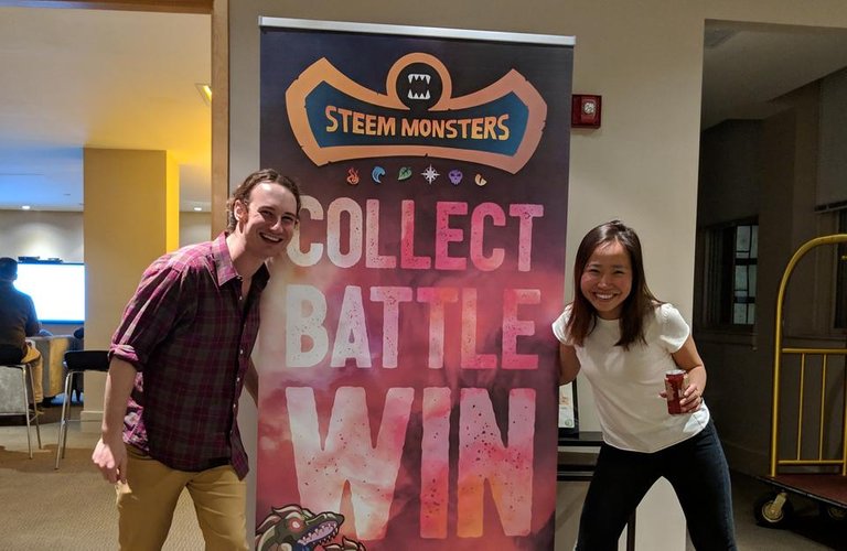 dhimmel and trang in front of steemmonsters banner jpg