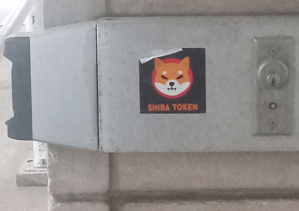 "SHIB TOKEN" sticker slapped outside the entrance to a bank's ATM lobby