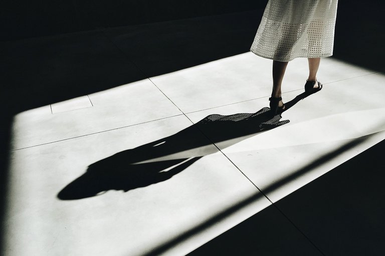 Woman walking, leaving a shadow