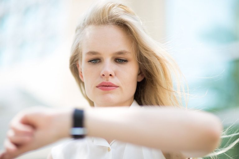 Woman looking at watch overwhelmed