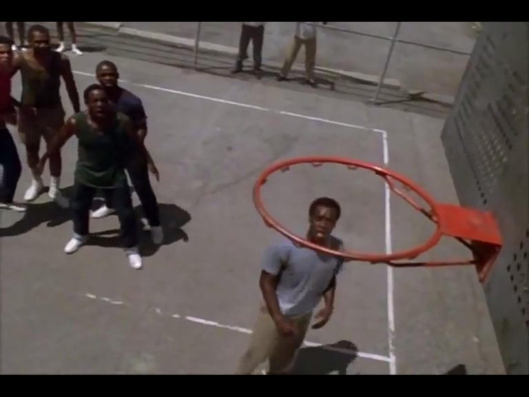 Escena de la película. Don Cheadle hace el papel de The Goat, es quien sale dentro del aro de baloncesto. // Scene from the movie. Don Cheadle plays the role of The Goat, is the one who appears inside the basketball hoop. Fuente/Source: https://m.imdb.com/title/tt0117450/mediaviewer/rm3661642240/