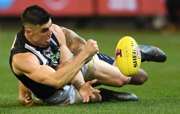 Brayden Maynard of the Magpies handballs whilst being tackled during the AFL 1st Qualifying Final match between the Geelong Cats and the Collingwood...