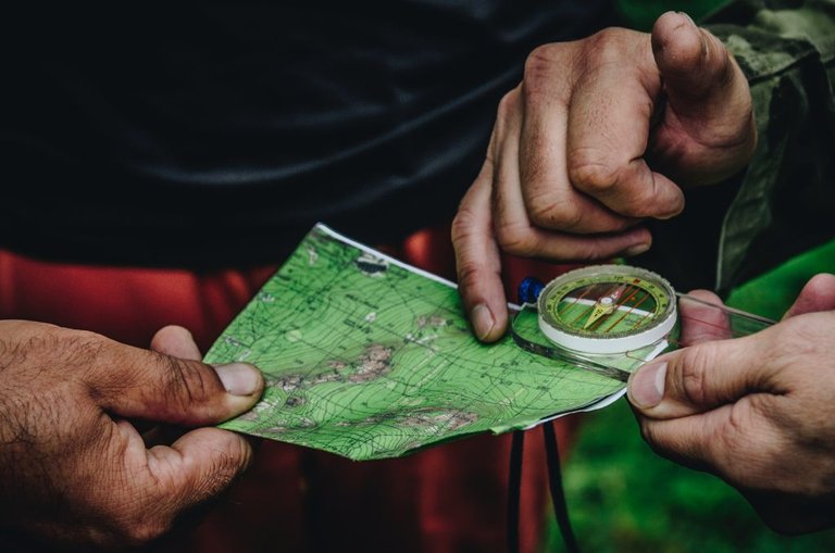 two rugged hikers consulting their map and compass