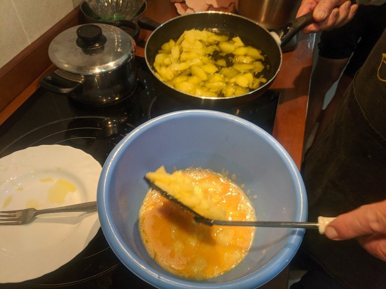 Fried potatoes are added to the omelette mix