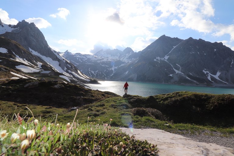 Lünersee Umrundung Frau steht in Richtig See, Berge im Hintergrund