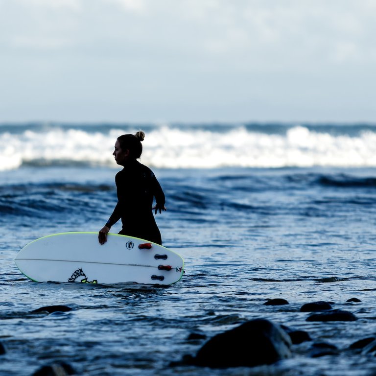 A couple of girls paddle out...