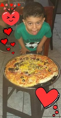 Mi pequeño feliz con su pizza/My little one happy with his pizza.