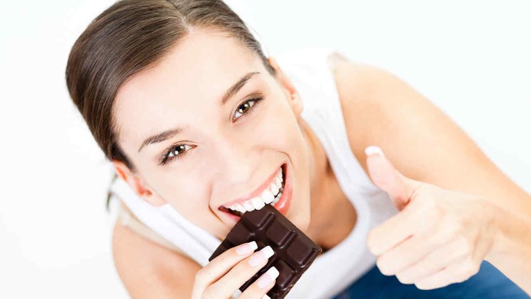 beneficios-del-chocolate-amargo-mujer-joven-comiendo-chocolate.jpg