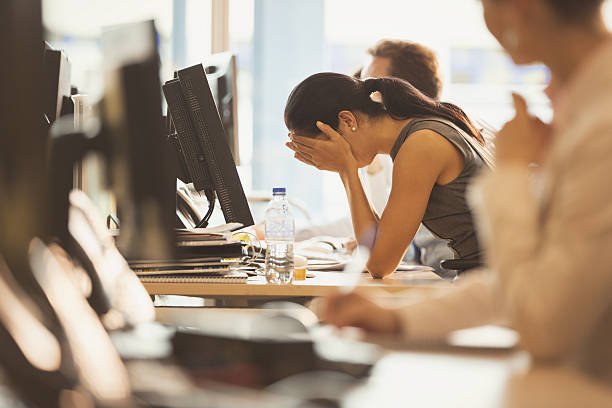 stressed-businesswoman-with-head-in-hands-at-office-desk-picture-id638681851.jpg