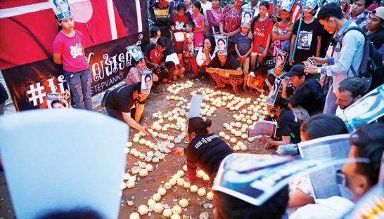 tep-vannys-daughter-kong-panha-left-stands-with-a-photograph-at-a-candelight-vigil-held-to-protest-the-boeung-kak-activists-year-of-detention.-pha-lina.jpg