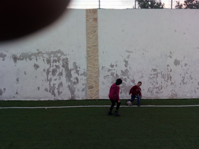 A brother and a sister playing football in the Haida camp