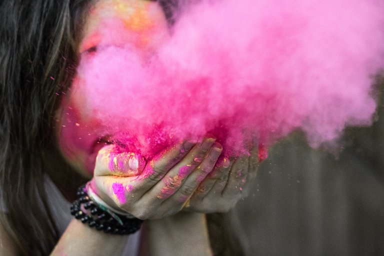 shallow-focus-photograph-of-woman-blowing-pink-powder.jpeg