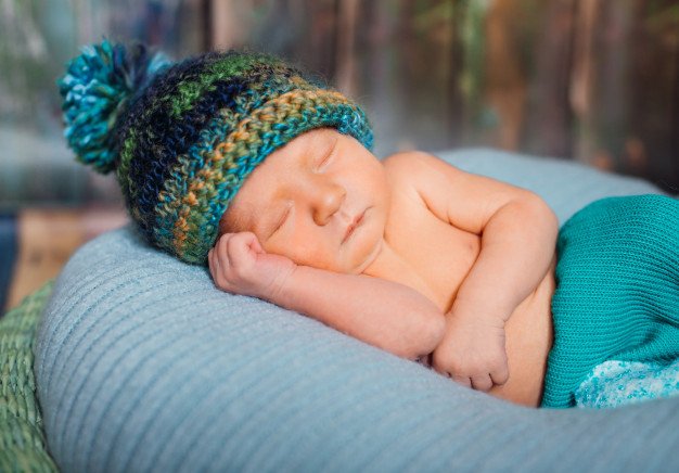 little-boy-in-knitted-hat-sleeps-on-large-blue-pillow_8353-856.jpg