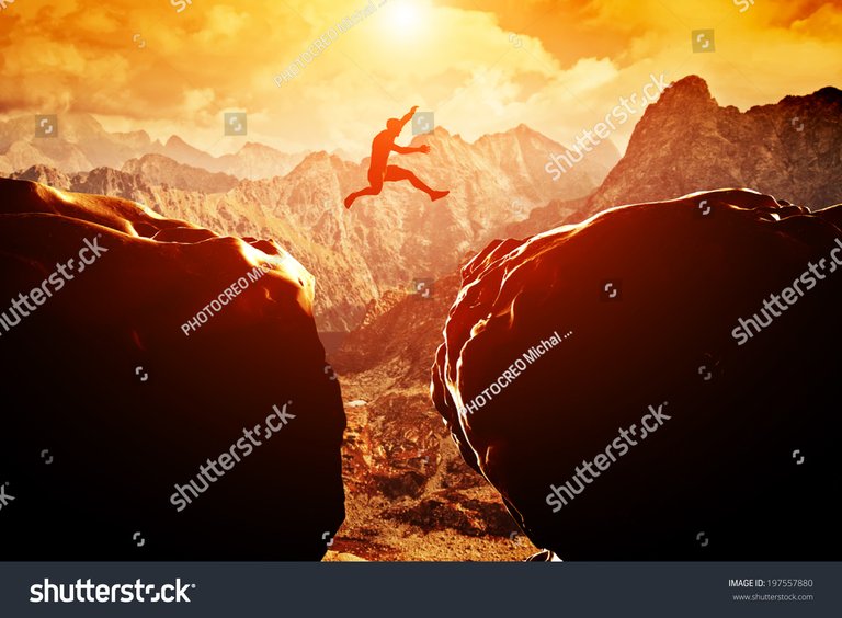 stock-photo-man-jumping-over-precipice-between-two-rocky-mountains-at-sunset-freedom-risk-challenge-success-197557880.jpg