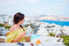 beautiful-woman-having-breakfast-outdoor-cafe-amazing-view-girl-enjoy-her-hot-coffee-early-morning-mykonos-town-87843382.jpg