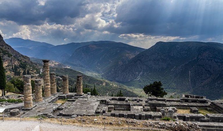 ancient-ruins-of-delphi-and-the-sun-peaking-through-the-clouds.jpg