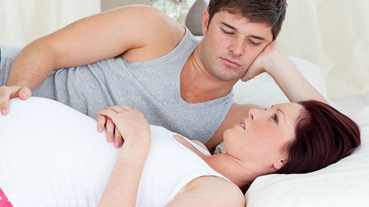 couple-talking-in-bed-about-pregnancy-complications.jpg