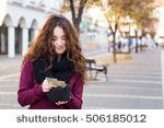 stock-photo-young-shopper-woman-taking-out-money-from-wallet-on-street-506185012.jpg