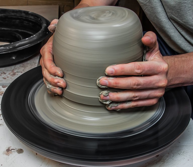 My hands throwing clay on the pottery wheel