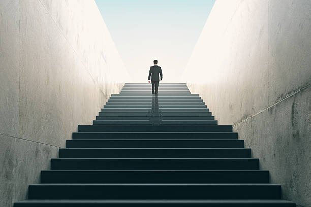 ambitions-concept-with-businessman-climbing-stairs-picture-id511601860.jpg