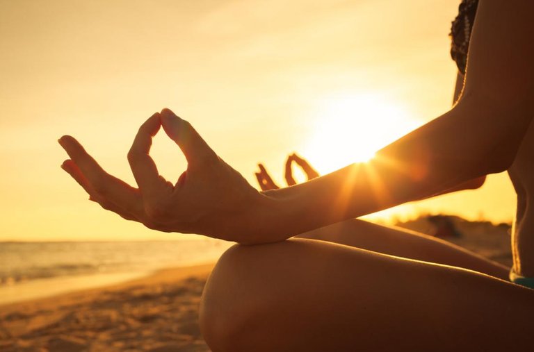 a-woman-meditating-on-a-beach.jpg