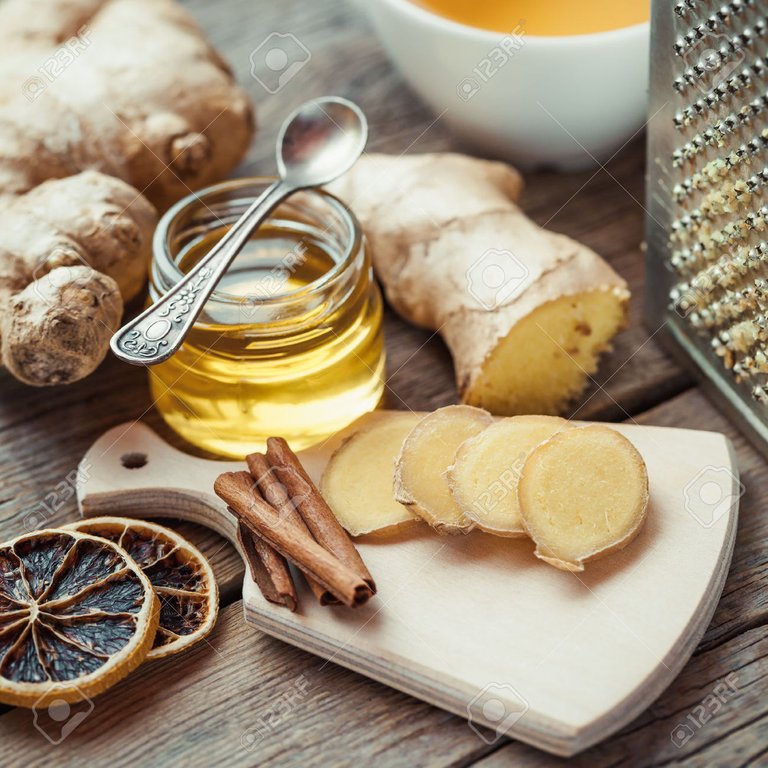 47628007-Ginger-on-cutting-board-jar-of-honey-dried-lemon-slice-cinnamon-and-grater-on-kitchen-table-Selectiv-Stock-Photo.jpg