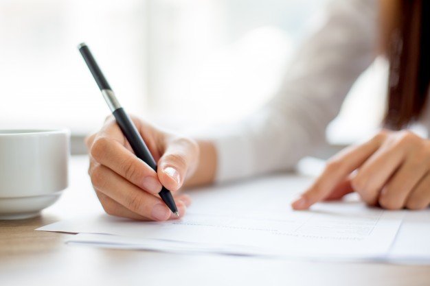 hand-of-businesswoman-writing-on-paper-in-office_1262-2119.jpg