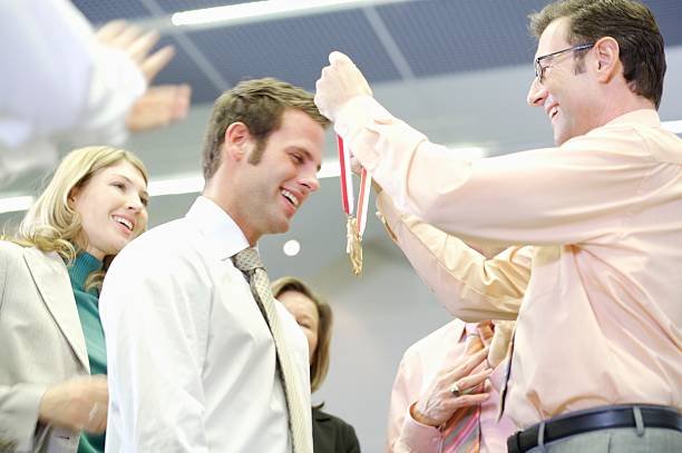 businessman-receiving-medal-from-coworkers-picture-id76509020.jpg