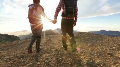 stock-footage-couple-holding-hands-hiking-outdoors-at-romantic-sunset-hikers-man-and-woman-lovers-trekking.jpg