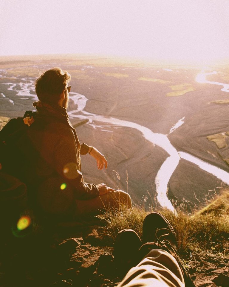 Taking a break in a cavern’s ledge on the side of a Icelandic mountain.