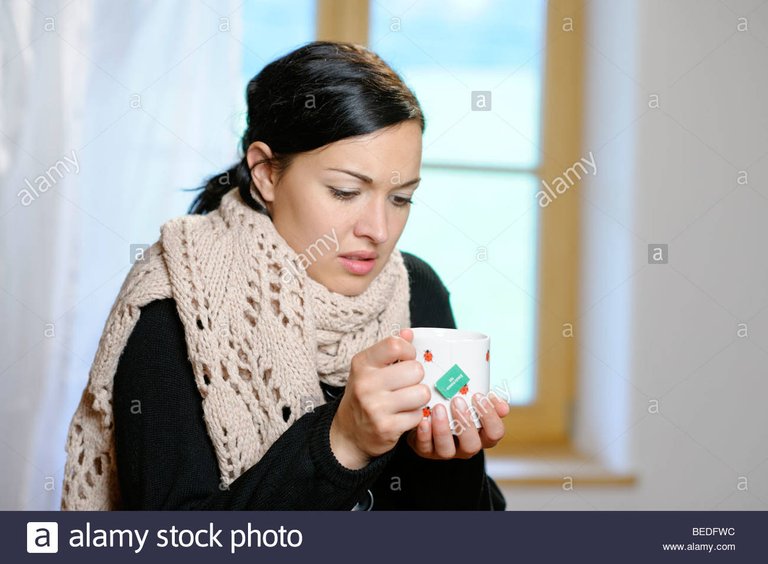 young-woman-with-a-cup-of-tea-getting-a-cold-flu-fever-feeling-cold-BEDFWC.jpg