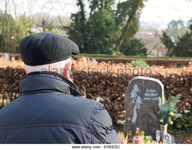 old-man-on-graveyard-looking-at-gravestone-ehxedj.jpg