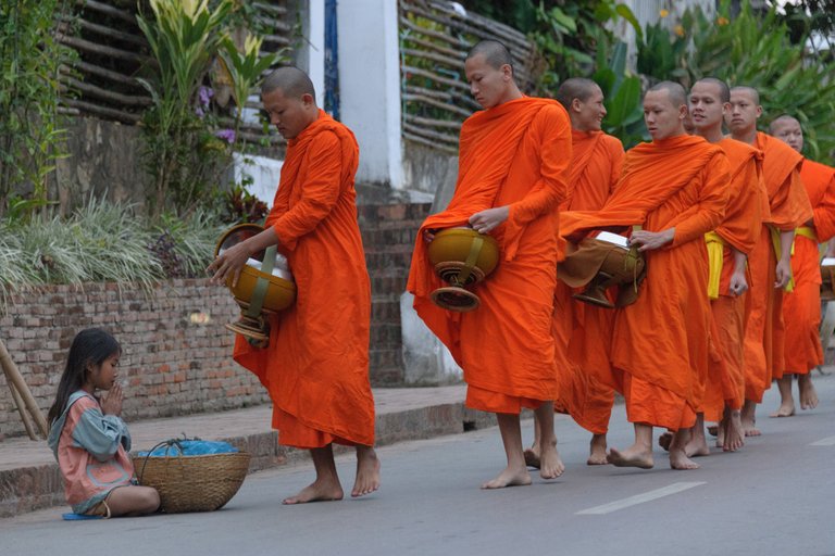 Bedelende monniken geven aan arm meisje.jpg