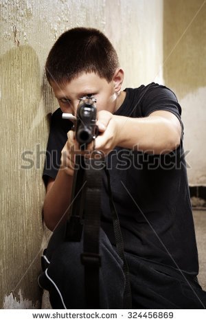 stock-photo-young-boy-handling-dangerous-gun-324456869.jpg