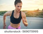 stock-photo-fit-determined-young-woman-runner-training-at-sunrise-on-a-rural-road-sprinting-towards-the-camera-569075995.jpg