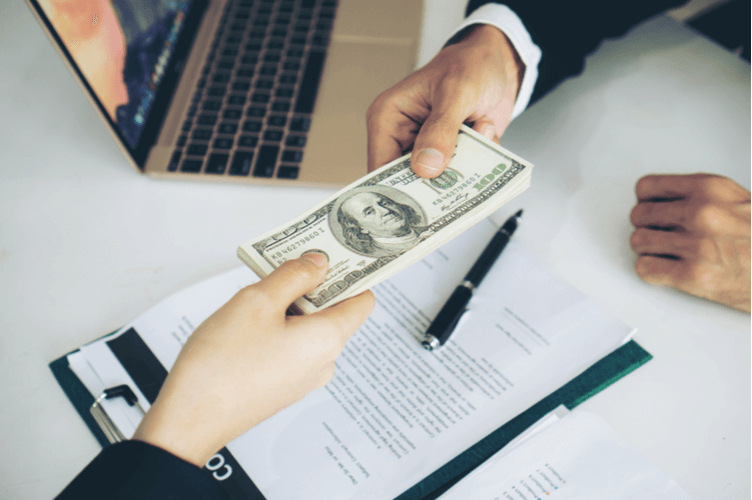 close up hand of business giving or paying money US dollar bill (1).png