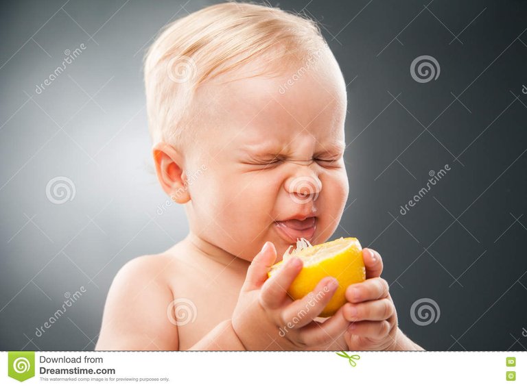 baby-squinting-eyes-licking-lemon-portrait-funny-sour-72601332.jpg