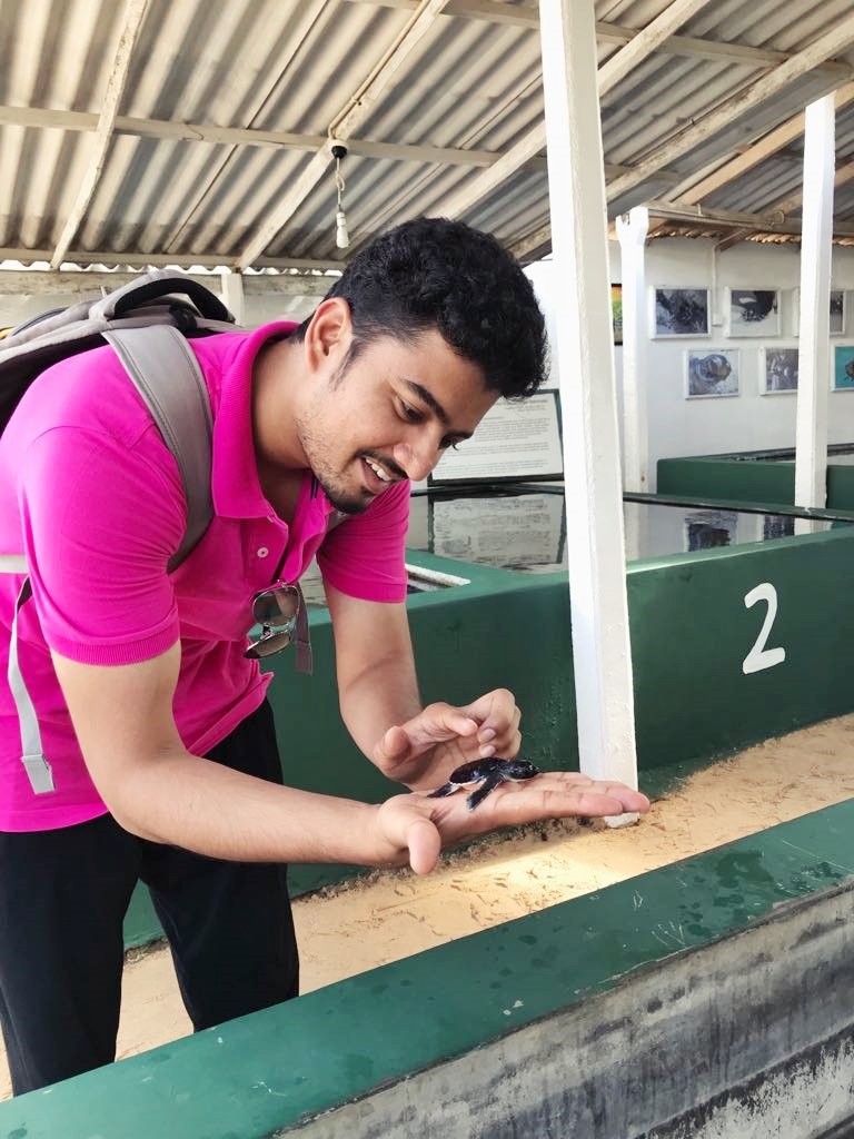 Me befriending a hatchling at the Sea Turtle Protection Center