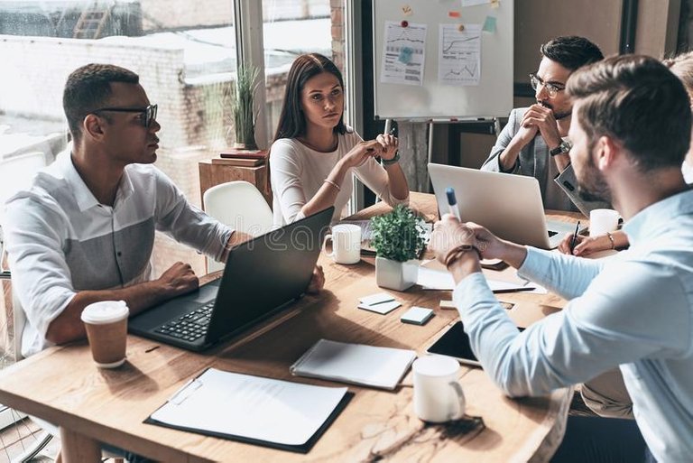 Young professional team. Top view of young modern people in smart casual wear discussing business while working in the creative o. Ffice stock images