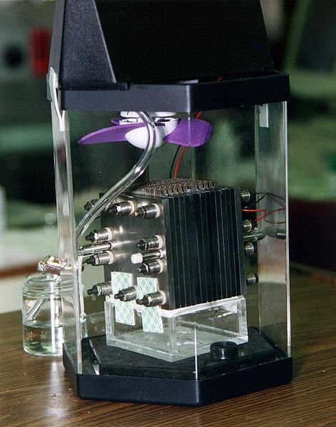 Demonstration model of a direct-methanol fuel cell (black layered cube) in its enclosure.